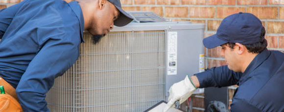 Two men working on an HVAC system
